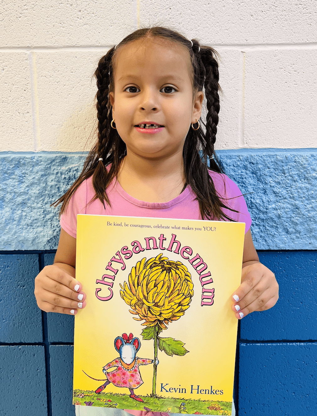 student holding a book received for earning a  praise award